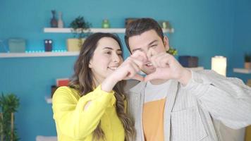 Married or beloved couple making heart and looking at camera. happy relationship. video