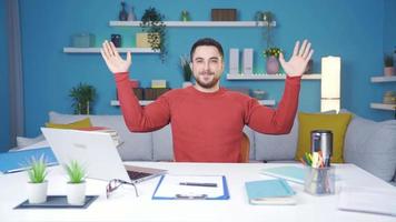 Young man showing how to exercise in the office. Doing wrist exercises. Man working from home showing how to do wrist exercise to camera. video