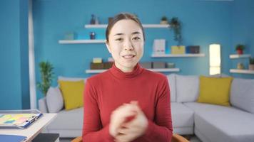 content asiatique femme joyeusement récit quelque chose vers caméra. asiatique Jeune femme souriant vers le caméra et récit quelque chose. video