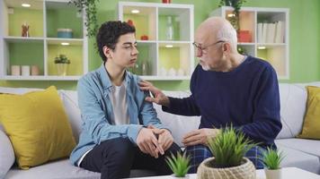 Opa gibt Rat zu seine neugierig Enkel. das kenntnisreich Großvater und das schön Enkel sind Sitzung auf das Sofa und Hören zu seine Großvater neugierig. video