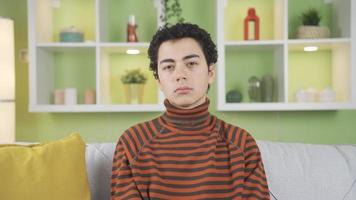 Portrait of depressed boy.  Boy alone at home looking at camera unhappy and depressed video