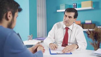 Senior psychologist doctor gives morale and support to his young patient.  The smiling psychologist man motivates his young patient as moral and support. video