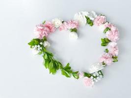 Frame in form of heart from pink, white carnations photo