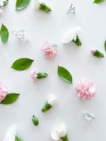 Floral pattern of pink and white carnations, green leaves photo