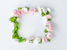 Square frame of pink and white carnations, leaves photo