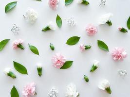 Floral pattern of pink and white carnations, green leaves photo