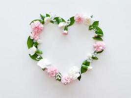 Frame in form of heart from pink, white carnations photo