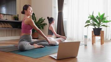 yoga en línea curso, asiático mujer y hija promueve bienestar, familia unión en vídeo conferencia video