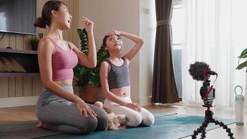 Experte asiatisch Yoga Lehrer und Tochter bringen Gesundheit und Fitness zu Häuser durch online Video Klasse