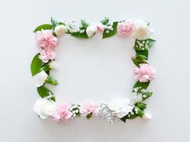 Square frame of pink and white carnations, leaves photo