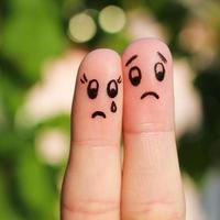 Finger art of displeased couple. Sad man soothe woman, she's crying. photo