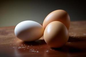 Chicken eggs, brown and white eggs on a table. Eggs ready to be used with flour and wheat in recipe on the table. Types of eggs used in cake preparation and various recipes. photo