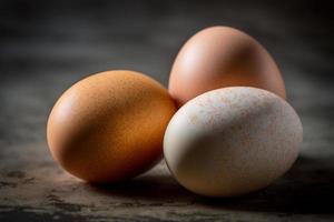 Chicken eggs, brown and white eggs on a table. Eggs ready to be used with flour and wheat in recipe on the table. Types of eggs used in cake preparation and various recipes. photo