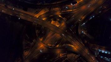 Vertical top down aerial view of traffic on freeway interchange at night, quickly speed video