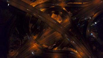 Vertical top down aerial view of traffic on freeway interchange at night, quickly speed video