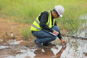 Environmental engineers work at water source to check for contaminants  in water sources and analysing water test results for reuse.World environment day concept. photo