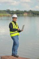 Environmental engineers work at water source to check for contaminants  in water sources and analysing water test results for reuse.World environment day concept. photo