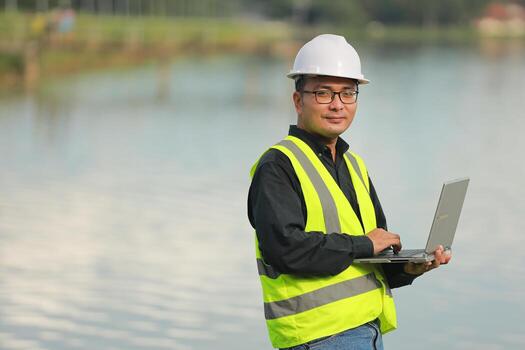 Environmental engineers work at water source to check for contaminants  in water sources and analysing water test results for reuse.World environment day concept. photo