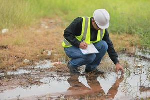 Environmental engineers work at water source to check for contaminants  in water sources and analysing water test results for reuse.World environment day concept. photo