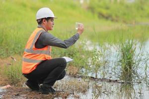 Environmental engineers work at water source to check for contaminants  in water sources and analysing water test results for reuse.World environment day concept. photo