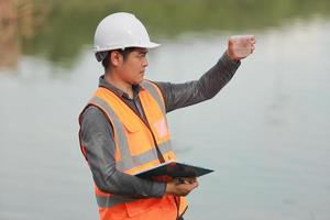 Environmental engineers work at water source to check for contaminants  in water sources and analysing water test results for reuse.World environment day concept. photo