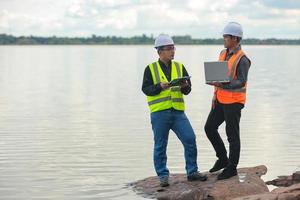 Environmental engineers work at water source to check for contaminants  in water sources and analysing water test results for reuse.World environment day concept. photo