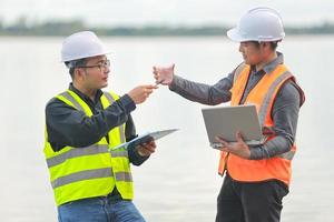 Environmental engineers work at water source to check for contaminants  in water sources and analysing water test results for reuse.World environment day concept. photo