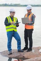 Environmental engineers work at water source to check for contaminants  in water sources and analysing water test results for reuse.World environment day concept. photo