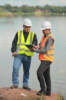 Environmental engineers work at water source to check for contaminants  in water sources and analysing water test results for reuse.World environment day concept. photo