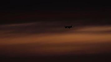 de vliegtuig Aan de laatste nadering voordat landen Aan de achtergrond van de zonsondergang schemer lucht video