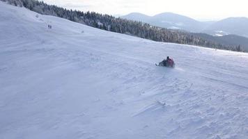 Aussicht von das Höhe von atvs Reiten durch das schneebedeckt Landschaft im Winter video