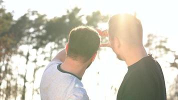 Jeune gay couple prise photo de eux-mêmes sur une film caméra dans le printemps soir video