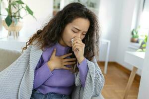 frío ,gripe tos. enfermo mujer tos sentado en sofá a hogar . asiático mujer siendo enfermo teniendo gripe acostado en sofá. frío gripe coronavirus, covid19 foto