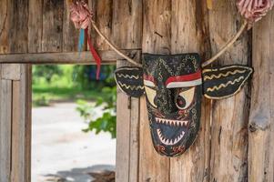 Phi Ta Khon mask hang on the wooden wall in thailand photo