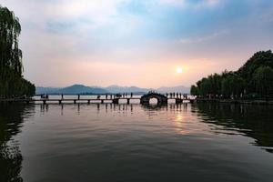 beautiful hangzhou in sunset, ancient pavilion silhouette on the west lake,China photo