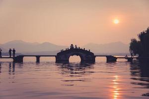 beautiful hangzhou in sunset, ancient pavilion silhouette on the west lake,China photo