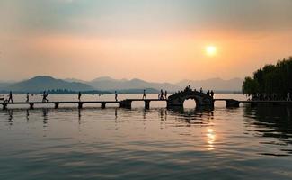 beautiful hangzhou in sunset, ancient pavilion silhouette on the west lake,China photo