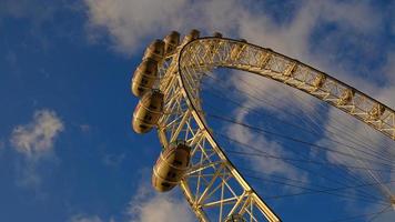 ferris rueda en el diversión parque en antecedentes de azul cielo con nubes bajo ángulo ver de un grande ferris rueda. foto