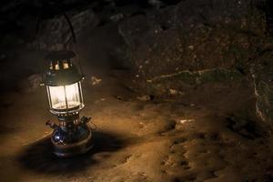 The old antique storm lantern in a cave photo