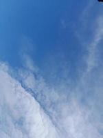 Beautiful white clouds on deep blue sky background. Large bright soft fluffy clouds are cover the entire blue sky. photo