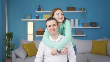 Young adult girl hugs her father. They are looking at the camera together. Girl hugs her father and looking at camera laughing together. They are happy and friendly. video