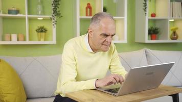 personnes âgées retraité homme en utilisant ordinateur à transfert argent ou faire financier Paiement en ligne. retraité vieux homme en utilisant portable à maison, payant factures en ligne, achats en ligne, Faire recherche. video