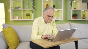 The old man who has trouble using a laptop at home is away from technology. At home, the old man does not use a laptop, he does his work on the Internet, he has difficulties. video