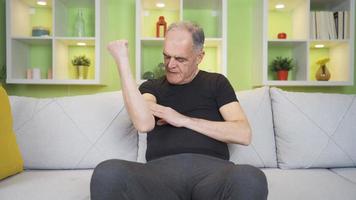 velho homem com dolorido músculos. velho homem com músculo dor toques dele músculos com dele mão. video