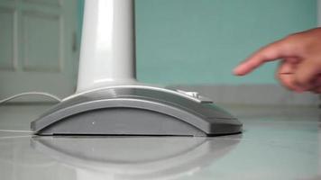 main tournant sur et de un électrique air ventilateur. électrique ventilateur glacière tourné sur avec pressage le bouton. sur et de bouton de une ventilateur video