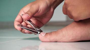 Close up of man cutting his foot nails. Hand cutting toenails video