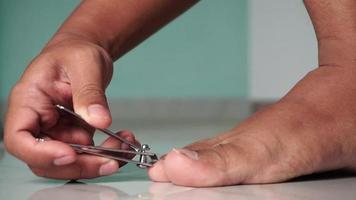 Close up of man cutting his foot nails. Hand cutting toenails video
