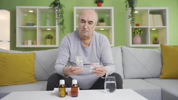 A senile old man taking medicine by heart. The grumpy, senile man using over-the-counter drugs. video