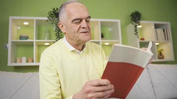 velho homem lendo uma livro às lar. velho homem lendo uma livro às casa sozinho dentro uma pacífico e relaxado humor. video