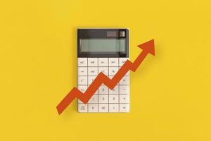 Calculator, graphs, arrow on yellow background. Financial development, Banking Account, Statistics photo